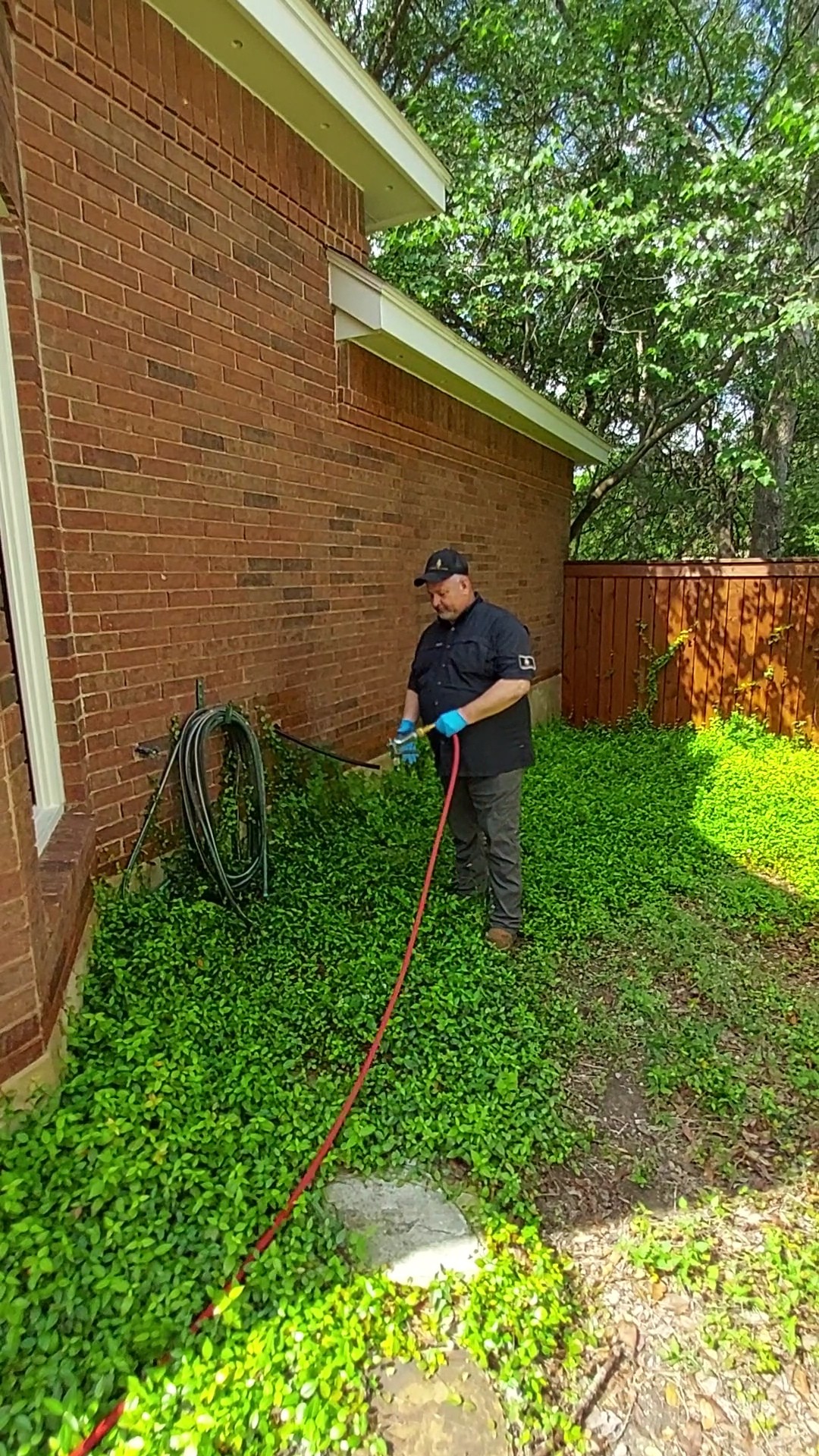 Stalwart technician treating the perimeter of a brick home